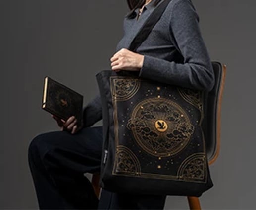 A life style shot of a woman sitting down while wearing the canvas bag.